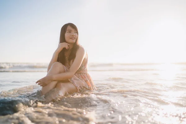 Junge asiatische Frau am Strand. schöne weibliche glücklich entspannen Spaziergänge am Strand in der Nähe des Meeres bei Sonnenuntergang am Abend. Lifestyle-Frauen reisen am Strand. — Stockfoto