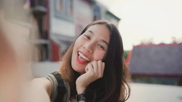 Vrolijke mooie jonge Aziatische backpacker blogger vrouw met behulp van smartphone selfie te nemen terwijl het reizen in Chinatown in Peking, China. Levensstijl rugzak concept van toeristische reizen vakantie. Point of view. — Stockfoto