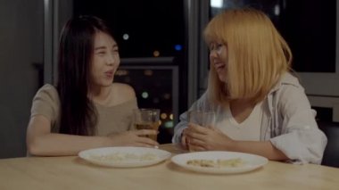 Lezbiyen lgbtq kadın çift parti evde, kadın gece oturma odasında kanepede birlikte eğlenceli mutlu an içme bira. Genç sevgilisi oyun, ilişki, tatil konsepti kutlamak.