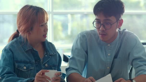 ラップトップで働く若いアジアのクリエイティブチームミーティング プロのビジネスマンと女性のグループは コーヒーを飲み 議論し 新しいアイデア ビジネス状況 現代のオフィスコンセプトでチームワークを考えます — ストック動画