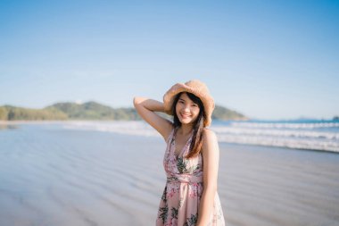 Sahilde yürüyen genç Asyalı kadın. Güzel kadın mutlu akşam gün batımı nda deniz kenarında sahilde yürüyüş rahatlayın. Yaşam tarzı kadın plaj konsepti seyahat.