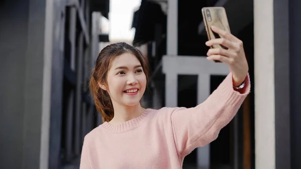 Iloinen kaunis nuori aasialainen reppumatkailija bloggaaja nainen käyttää älypuhelinta selfie matkustaessaan Chinatownissa Pekingissä, Kiinassa. Elämäntapa reppu turisti matka loma käsite . — kuvapankkivalokuva