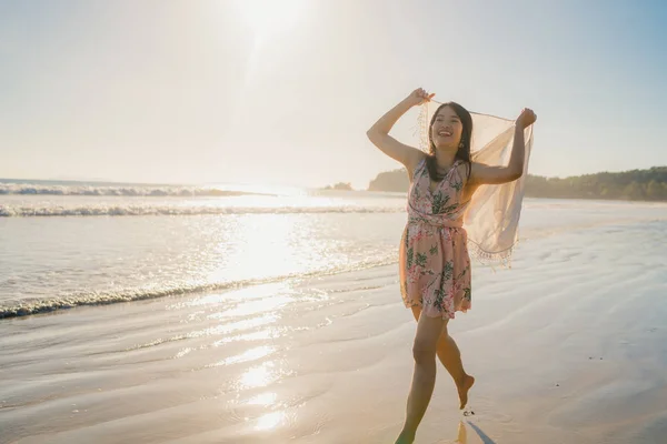 Jovem mulher asiática correndo e brincando na praia, bela fêmea relaxar na praia perto do mar quando o pôr do sol à noite. Estilo de vida mulher viajar no conceito de praia . — Fotografia de Stock