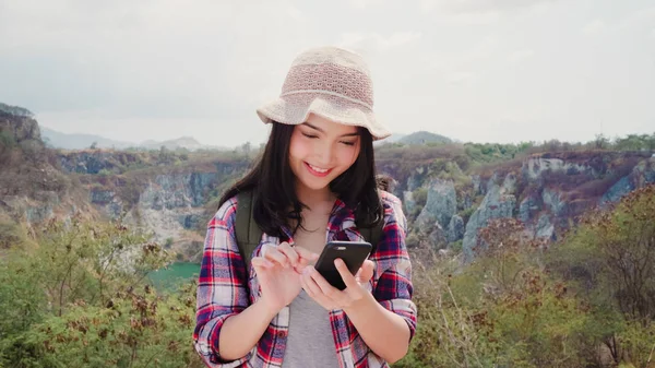 Mujer mochilera asiática en la cima de la montaña, joven mujer feliz usando el teléfono móvil disfrutar de vacaciones en la aventura de senderismo. Estilo de vida de las mujeres viajan y relajarse concepto . —  Fotos de Stock