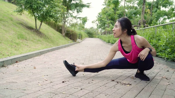 Saudável bela jovem atleta asiático mulheres em esportes roupas pernas aquecendo e esticando os braços para pronto para correr na rua no parque urbano da cidade. Estilo de vida mulheres ativas exercício no conceito de cidade . — Fotografia de Stock