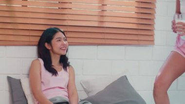 Asyalı Lezbiyen lgbtq kadın çift evde kahvaltı var. Genç Asya sevgilisi kız mutlu sabah kavramı evde yatak odasında yatakta yatarken uyandıktan sonra süt içmek içmek dinlenmek.