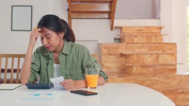 Evde gelir ve giderler iş Asyalı kadın kayıtları, Genç Asya kız endişeli, ciddi, stres laptop kayıt bütçesi, vergi, mutfak konsepti çalışma mali belge kullanırken.