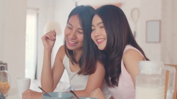 アジアのレズビアンLgbtqインフルエンサー女性カップルVlog自宅で ソーシャルメディアでタブレットVlogビデオを使用して幸せな若いアジアの女の子は 朝のコンセプトでキッチンで朝食を持っている間 結婚指輪を示しています — ストック動画