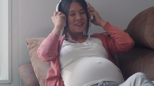 Joven Asiática Embarazada Mujer Usando Teléfono Auriculares Reproducir Música Para — Vídeos de Stock