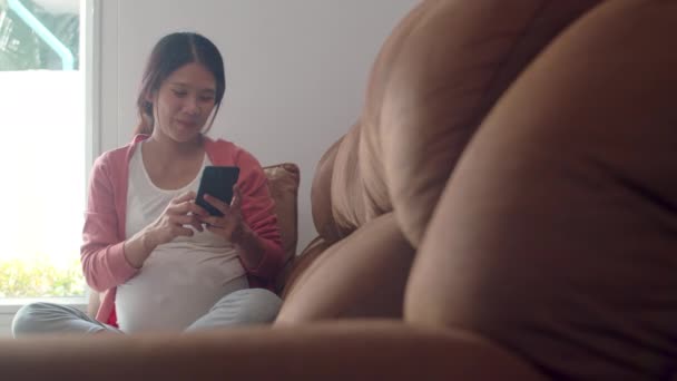 Молода Азіатська Вагітна Жінка Допомогою Мобільного Телефону Пошук Вагітності Інформації — стокове відео