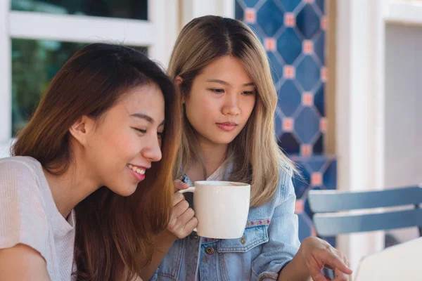 Jovens mulheres asiáticas em roupas casuais inteligentes trabalhando enviando e-mail no laptop e bebendo café enquanto estão sentadas no café. Estilo de vida mulheres comunicação e trabalhando no conceito de café . — Fotografia de Stock