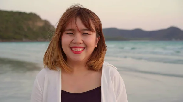 Nuori aasialainen nainen onnellinen rannalla, kaunis nainen onnellinen rentoutua hymyillen hauskaa rannalla lähellä merta, kun auringonlasku illalla. Elämäntapa naiset matkustavat rannalla käsite . — kuvapankkivalokuva