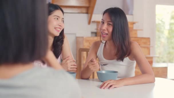 アジアの女性は自宅で朝食を食べ 若いアジアの友人の女の子のグループは 朝のコンセプトでキッチンで朝食を食べながら一緒に話して幸せな楽しみを感じています — ストック動画