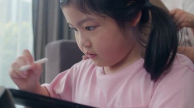 Asyalı dedesi ve torunu evde tablet çizim. Üst düzey Çinli, büyükbaba ve büyükanne mutlu oturma odası kavramı kanepede yatan genç kız ile aile zaman dinlenmek harcamak. Yavaş çekim.