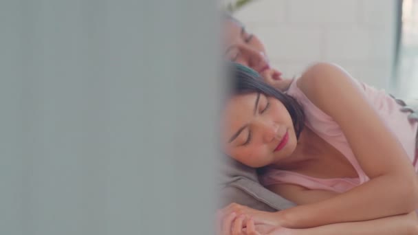 アジアのレズビアンLgbtq女性カップルは自宅で目を覚ます 若いアジアの恋人の女性は 朝のコンセプトで自宅の寝室でベッドに横たわっている間 一晩中ベッドで寝た後に一緒にリラックスリラックス — ストック動画