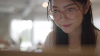 Ofiste dizüstü bilgisayar üzerinde çalışan serbest Asyalı kadınlar. Genç Asya iş Kız ticaret için bilgisayar kullanarak, işyeri kavramı masada internet üzerinde e-posta, dijital çalışma göndermek. Yavaş çekim.