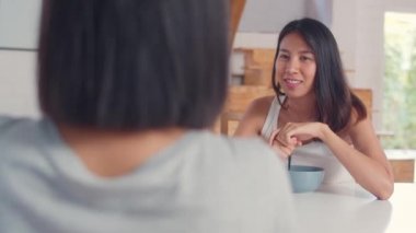 Asya Kadınlar evde kahvaltı var, Genç Asya arkadaşı kız grup sabah konsepti mutfakta kahvaltı yaparken birlikte konuşurken mutlu eğlenceli hissi. Yavaş hareket.