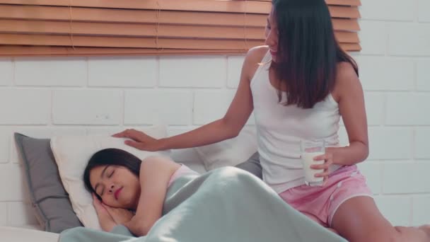 アジアのレズビアンLgbtq女性カップルは 自宅で朝食を持っています 若いアジアの恋人の女の子は朝のコンセプトで自宅の寝室でベッドに横たわって目を覚ました後 幸せなリラックスドリンクミルク — ストック動画