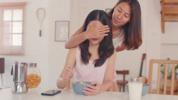 アジアのレズビアンLgbtq女性カップルは 現在の家を与え 若いアジアの恋人の女の子は 朝のコンセプトでキッチンで朝食を持っている間 彼女の誕生日やバレンタインデーに幸せな驚き — ストック動画