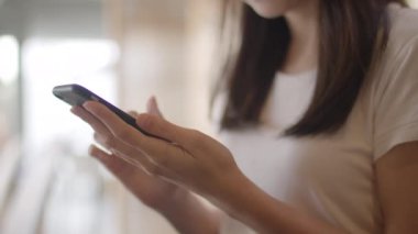 Ofiste cep telefonu kullanan serbest Asyalı kadınlar. Genç Japon Asya Kız işyeri kavramı masada internet üzerinden sosyal medya kontrol akıllı telefon kullanarak. Yavaş çekim.