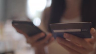 Ofiste Serbest Asya kadın online alışveriş. Genç Japon Asya Kız cep telefonu kullanarak, kredi kartı satın almak ve işyeri kavramı masada internet üzerinden e-ticaret satın. Yavaş çekim.