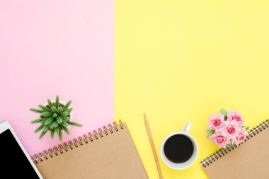 Ofis Masası adlı kullanıcının alanı - düz çalışma üstten görünüm fotoğraf çalışma alanı boş sahte tablet, kahve fincanı ve defter pastel zemin üzerine yatırın. Pastel pembe sarı renkli kopya alanı çalışma Resepsiyon kavramı.