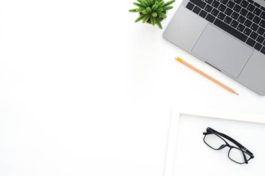 Yaratıcı düz Fotoğraf çalışma masası yatıyordu. Üstten görünüm ofis büro dizüstü bilgisayar, Gözlük, kalem ve beyaz renk arka plan üzerinde bitki. Kopya alanı, düz yatıyordu fotoğraf ile üstten görünüm.