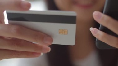 Serbest Asya kadın kahve dükkanında online alışveriş. Genç Asya Kız cep telefonu kullanarak, kredi kartı satın almak ve akşam konsepti açık kafede masada e-ticaret internet satın. Yavaş çekim.