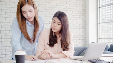 Smart casual kadınlarda çekici akıllı yaratıcı Asya iş çalışma masa ofis masasında otururken dizüstü bilgisayarda giymek. Yaşam tarzı kadın iş yerinde office kavramı.