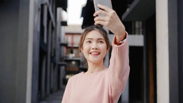 Alegre hermosa joven bloguera mochilera asiática utilizando teléfono inteligente tomar selfie mientras viaja en Chinatown en Beijing, China. Estilo de vida mochila turista viaje vacaciones concepto . —  Fotos de Stock