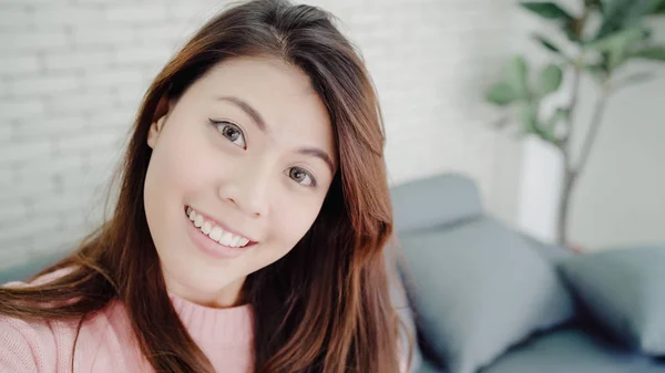 Aasian bloggaaja nainen käyttää älypuhelimen tallennus vlog video olohuoneessa kotona, nainen nauttia hauska hetki makaa sohvalla, kun rentoutua kotona. Elämäntapa bloggaaja tekee videon kotona . — kuvapankkivalokuva