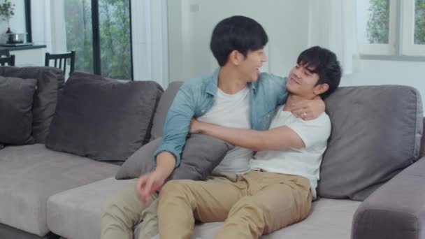 若いアジアのゲイのカップルは 自宅で抱擁し 魅力的なアジアのLgbtqプライド男性は リビングルームのコンセプトでソファを横たえながら 一緒にロマンチックな時間を過ごす幸せなリラックス スローモーションショット — ストック動画
