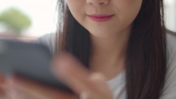 自由职业者在咖啡店使用手机 年轻的亚洲女孩使用智能手机检查社交媒体互联网在户外咖啡馆的桌子上在晚上的概念 慢动作 — 图库视频影像