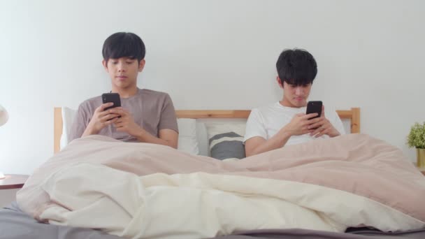 亚洲同性恋夫妇在家里使用手机 年轻的亚洲Lgbtq男人快乐地放松休息后醒来 检查社交媒体躺在床上 在卧室在早晨的概念 慢动作射击 — 图库视频影像