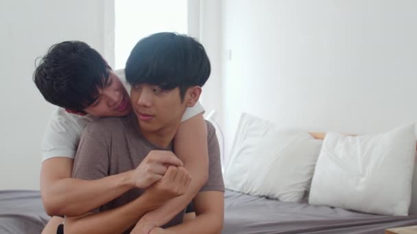 アジアのゲイのカップルは 自宅でベッドにキス 若いアジアのLgbtqの男性は 朝のコンセプトで自宅の寝室で目を覚ました後 一緒にロマンチックな時間を過ごす幸せなリラックスした時間を過ごします スローモーションショット — ストック動画