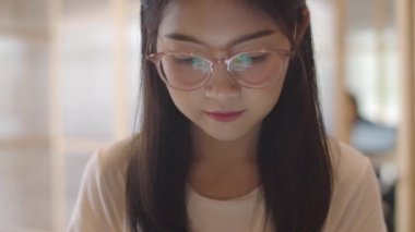 Ofiste cep telefonu kullanan serbest Asyalı kadınlar. Genç Japon Asya Kız işyeri kavramı masada internet üzerinden sosyal medya kontrol akıllı telefon kullanarak. Yavaş çekim ve Çekimi kapat.