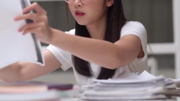 亚洲学生妇女读图书馆的书籍在大学 年轻的本科生女孩在大学校园的课桌上做作业 读课本 努力学习知识和教育 慢动作 — 图库视频影像
