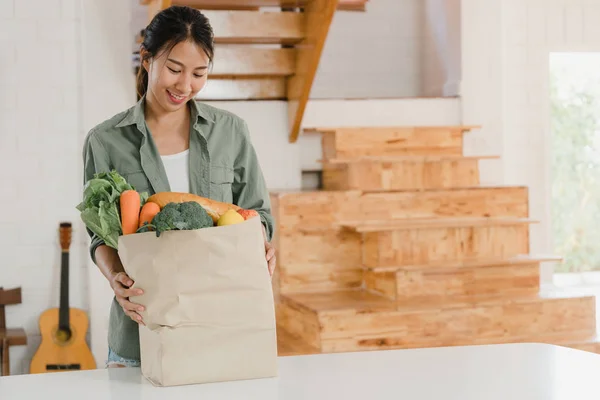 Ázsiai nők gazdaság bevásárlás papír zacskó otthon, fiatal ázsiai lány boldog vásárolni zöldségek és gyümölcsök egészséges és organikus termék szupermarket tedd a konyhában a reggeli koncepció. — Stock Fotó