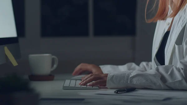 Jovem mulher asiática trabalhando até tarde usando desktop na mesa na sala de estar em casa. Ásia mulher de negócios escrever notebook finanças documento e calculadora à noite no escritório em casa. Conceito feminino sobrecarregado . — Fotografia de Stock