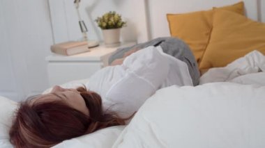 Asyalı büyükanne evde uyuyor. Üst düzey Çinli, büyükanne mutlu genç torunu kız gece konsepti evde yatak odasında yatakta yatarken uyanma köpüğü ile rahatlayın. Yavaş çekim.