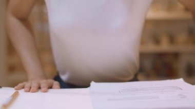 Asyalı öğrenci kadınlar üniversitede kütüphanede kitap okuyor. Genç lisans kız ev ödevi yapmak, ders kitabı okumak, üniversite kampüsünde ders masasında bilgi için çok çalışmak fazla mesai gece. Yavaş çekim.