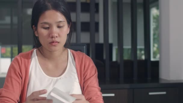 若いアジア妊娠中の女性の収入と家庭での費用の記録 お母さんは家のコンセプトでリビングルームで働いて予算 財務書類を記録しながら 深刻なストレス — ストック動画