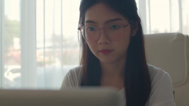 オフィスでラップトップで働くフリーランスのアジアの女性 若いアジアのビジネスガールは 貿易のためにコンピュータを使用して 職場のコンセプトでテーブル上のインターネット上の電子メール デジタル作業を送信します スローモーション — ストック動画