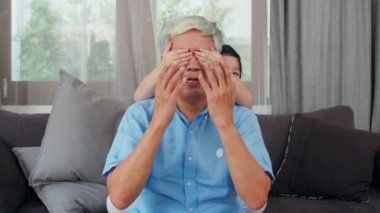 Asyalı dedesi evde dinlenmek. Üst düzey Çinli, dedesi mutlu genç torunu kız ile dinlenmek gözlerini sürpriz oturma odası kavramı birlikte oynarken yakın tadını çıkarın. Yavaş çekim çekimi.