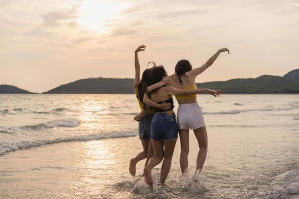 Grupo de três jovens mulheres asiáticas correndo na praia, amigos feliz relaxar se divertindo brincando na praia perto do mar, quando o pôr do sol à noite. Estilo de vida amigos viagem férias na praia verão conceito . — Fotografia de Stock