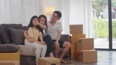 Mutlu Asyalı genç aile sahipleri yeni bir ev satın aldı. Japon anne, baba ve kızı yeni bir eve taşınıp koltukta birlikte oturmayı dört gözle bekliyor..
