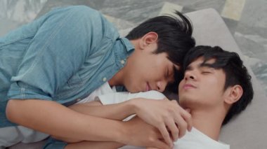 Genç Asyalı eşcinsel çift evde birlikte yatıyor. Genç Koreli Lgbtq erkekleri mutlu. Rahat olun. Sabahları yatak odasında dinlenin..