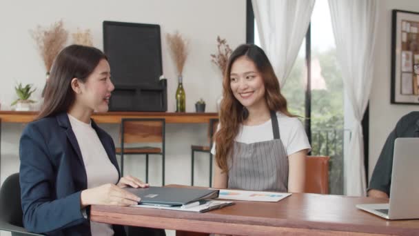 兴高采烈的亚洲小企业主夫妇在咖啡店与顾问会面 讨论商业计划和金融问题 年轻的日本代理考虑在餐馆共同签署合同保险 — 图库视频影像
