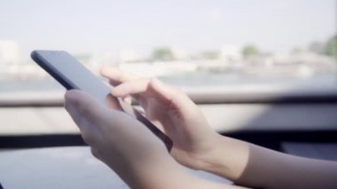 Açık kafede cep telefonu kullanan Asyalı turist kadınlar. Genç Japon Asyalı kız akıllı telefon kullanıyor sosyal medyayı kontrol ediyor ve sosyal ağdaki arkadaşlarıyla mesajlaşıyor tatilin tadını çıkarıyor..