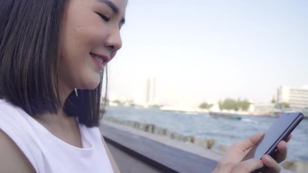Femmes asiatiques touristiques utilisant téléphone portable au café extérieur. Jeune fille japonaise Asie en utilisant smartphone vérifier les médias sociaux et envoyer des SMS avec des amis sur les réseaux sociaux profiter du voyage vacances Voyage .